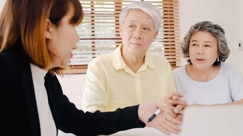Woman Talking to Elderly Couple About Using Broker to Buy Medical Health Insurance