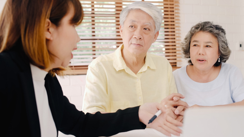 Woman Talking to Elderly Couple About Using Broker to Buy Medical Health Insurance